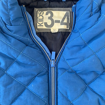 Close-up of zipper on toddler boys blue puffer vest