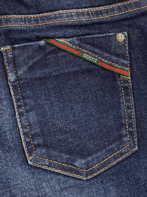 Side view of kid's straight-leg blue denim jeans by Gucci