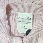 Tag detail highlighting Aster & Oak branding on baby cardigan