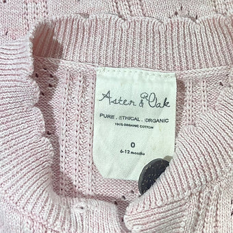 Tag detail highlighting Aster & Oak branding on baby cardigan