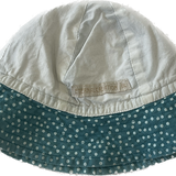 Side view of the Eternal Creation teal polka-dot baby hat with a bow detail.